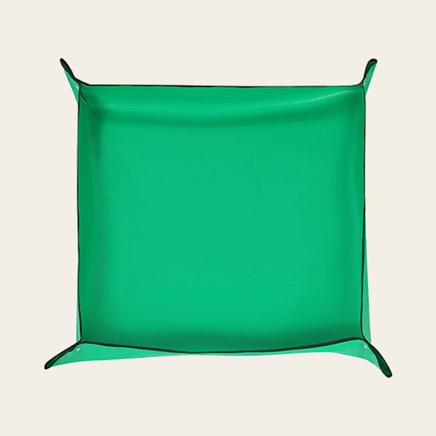The green mat with all four corners snapped up into a tray